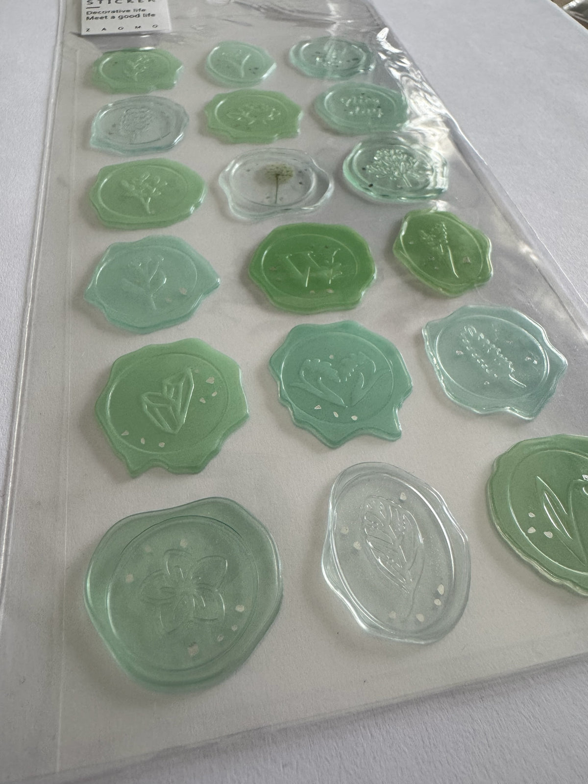 Set de stickers Brena con diseño de sello de cera en tonos verdes, motivos botánicos y acabado semitransparente.
