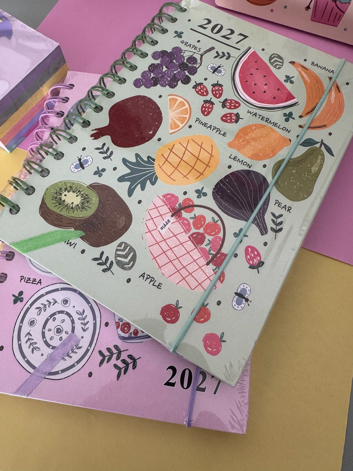 Set de agenda anual 2027 Brena con ilustraciones de frutas y diseño de espiral, incluye accesorios de maquillaje