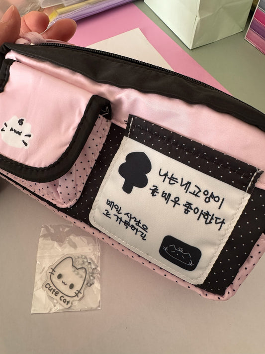 Cartuchera Brena rosa y negra con estampado de lunares, diseño de gato y llavero decorativo para útiles escolares.
