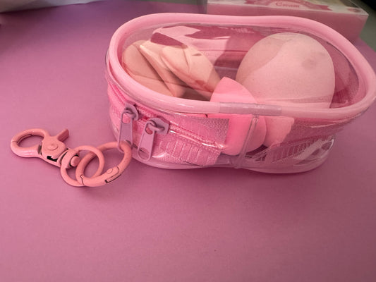 Estuche organizador Brena transparente con esponjas de maquillaje rosadas de diversas formas y gancho mosquetón