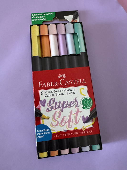 Set de 6 marcadores Brena Faber-Castell Super Soft con punta pincel en tonos pastel sobre fondo lila