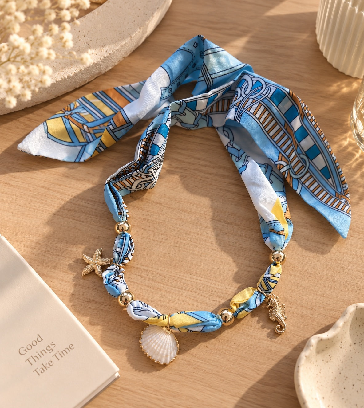 Gargantilla Brena de pañuelo en seda azul y amarillo con dijes de estrella de mar, caballito de mar y concha marina.
