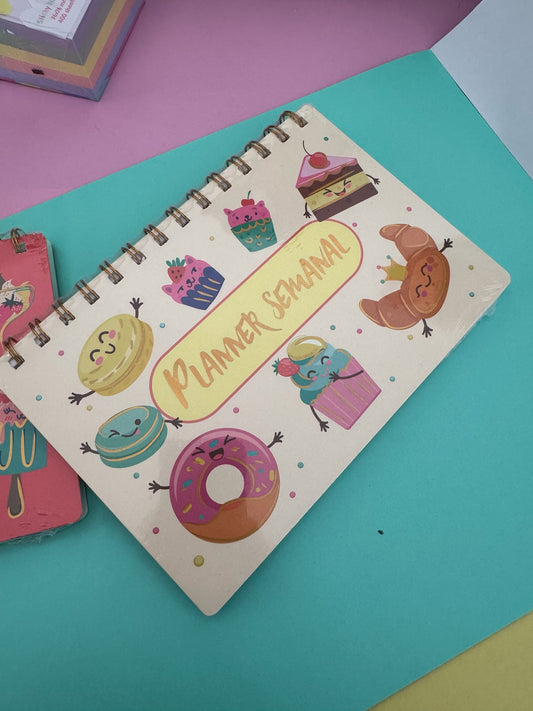 Planner semanal Brena con espiral metálica, portada ilustrada con dulces, postres coloridos y personajes tiernos.