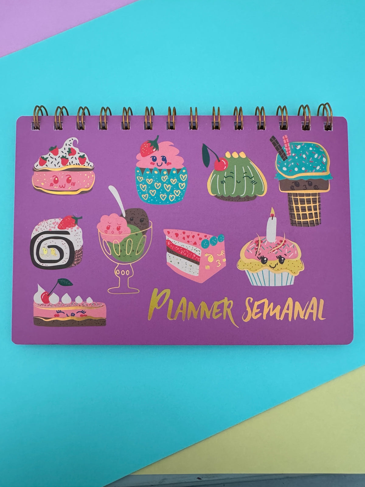 Planner semanal Brena con espiral metálica y portada morada decorada con ilustraciones kawaii de postres coloridos