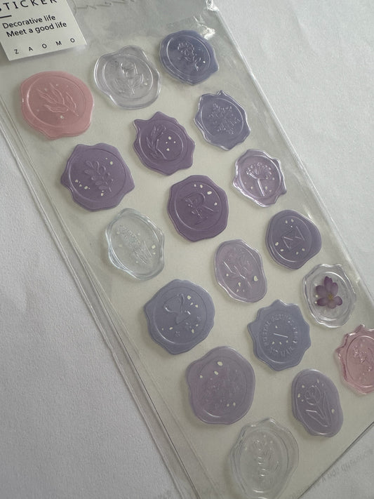 Set de pegatinas Brena con diseño de sello de cera en tonos lavanda, violeta y rosa para scrapbooking y papelería.
