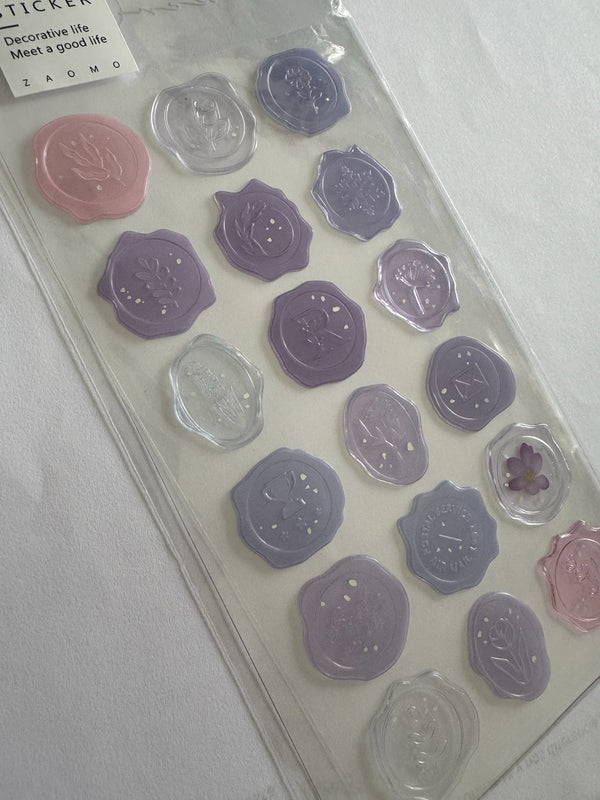 Set de pegatinas Brena con diseño de sello de cera en tonos lavanda, violeta y rosa para scrapbooking y papelería.